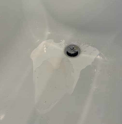 Porcelain tub stained all over by gases from drain cleaner